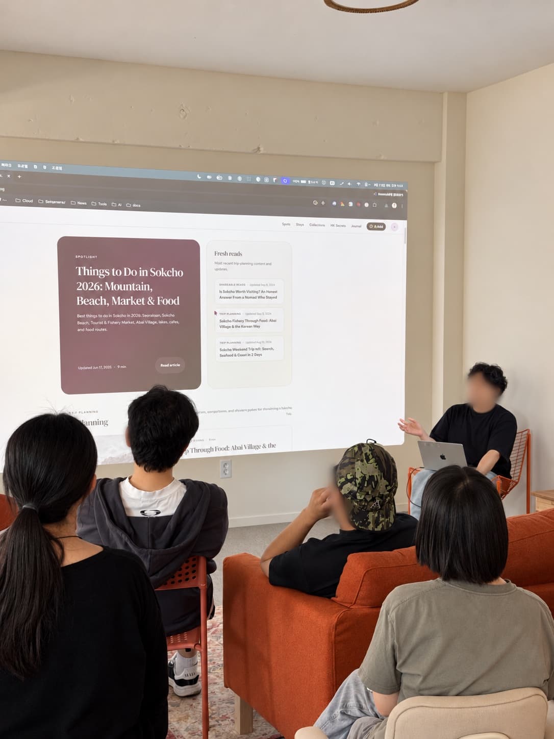 주황색 소파에 앉아 발표를 듣는 참가자들